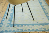 Vintage Dhurrie rug with denim blue geometric star border and soft field pattern.