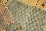 Plush pile of the vintage Gabbeh rug with asymmetric faded checkered pattern in pale green and natural grey.