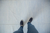 Close-up of the hand woven Dhurrie rug's subtle pale powder blue and ivory texture.