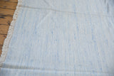 Hand-woven Dhurrie carpet texture, subtle powder blue, denim blue, ivory tones, showing fringe.