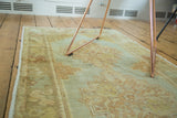 Stepped outline medallion with pastel sea foam green and peach tones, showing even wear.