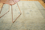 Vintage Oushak rug detail, carved ivory pile with scattered blue motifs and border.
