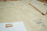 Partially carved ivory pile with scattered pale blue motifs on a vintage Oushak rug.