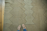 Textured vintage Oushak rug showing neutral beige tones, even wear, and a charcoal zigzag design.