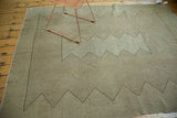 Minimalist zigzag motif in charcoal brown on the neutral distressed Oushak carpet.