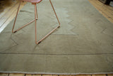 Vintage distressed Oushak rug showing neutral tones, charcoal zigzag pattern, and fringed edge.