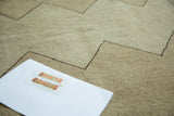 Distressed vintage Oushak rug pattern with beige tones, charcoal zigzag, and worn pile texture.