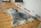Luxurious Angora skin rug displaying a soft blend of ivory, grey, and charcoal fur.