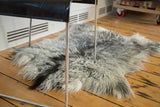 Angora skin rug with soft, shaggy fur texture in varying grey, charcoal, and ivory tones.