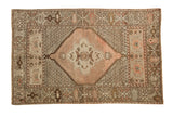 Hand knotted Vintage Oushak rug with peach hexagonal medallion, earth tone repeating patterns.
