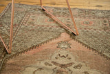Vintage Oushak rug detail showing peach, blush, and brown geometric patterns with a serrated border.