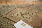 Oushak rug detail: hexagonal medallion and allover pattern in peach, blush, ivory, brown.