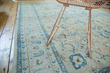 Intricate blue border and aged scrolling palmettes on a sand-toned vintage Tabriz rug.