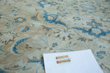 Vintage Tabriz carpet pile showing subtle distress on sand field with blue palmette motifs.