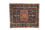 Distressed Heriz square rug with ornate medallion, geometric field in indigo blue, rust, and ivory.