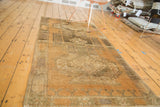 Vintage Oushak rug with distressed copper and bronze tones, featuring geometric medallion and border motifs.