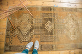 Distressed Oushak rug showing geometric wave motif, crab design, and lovely abrash texture.