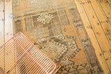 Hand knotted Oushak rug section with geometric patterns, abrash, and distressed copper tones.