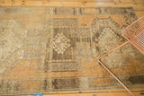 Detail of vintage Oushak rug with distressed geometric motifs in copper, brown, and ivory.