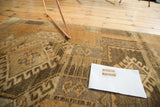 Vintage Oushak rug with geometric patterns and abrash in copper, bronze, and ivory tones.