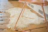 Luxurious ivory angora skin rug displaying its soft, shaggy texture.