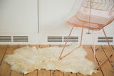 Luxurious ivory angora skin rug with a soft, shaggy texture.