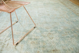 Textured distressed Oushak rug featuring pale mint, ivory, and beige geometric motifs.