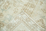 Distressed vintage Oushak rug corner, revealing hand-knotted foundation and faded geometric patterns.