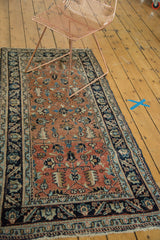 Antique Heriz runner with dark peach field, geometric florals, and navy floral wave border.