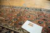Antique Heriz runner with geometric, floral, and wave motifs in soft brick red and navy.