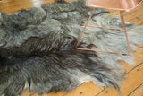 Luxurious angora skin rug's textured fur, showing blended silver, grey, and charcoal patches.
