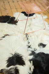Soft ivory and jet black Angora skin rug, showcasing a cowhide-like fur pattern.