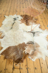 Textured Angora skin rug, showing blended ivory, silver, brown, and black fur.