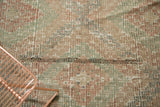 Hand woven texture of vintage Jijim carpet, geometric diamonds, brick red, green, and weave variation.