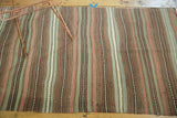 Hand woven Kilim rug with warm earth tone, blush, sea foam green stripes.
