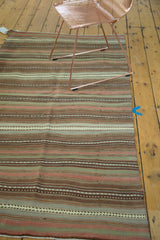 Close-up of alternating striped pattern in ivory, sea foam green, bronze, and blush.