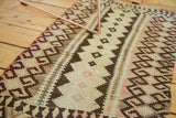 Hand woven vintage Kilim rug with blush and brown geometric crab style motifs.