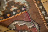 Hand woven Turkish Kilim rug showing flat weave texture, secured edge, and geometric pattern.