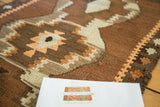 Stepped geometric pattern and reciprocating border in charcoal, tangerine, and ivory.