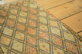 Intricate pale green, tangerine, and brown diamond lattice on a hand woven vintage Jijim rug.