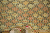 Hand woven vintage Turkish jijim rug with geometric diamonds in green, red, and orange tones.