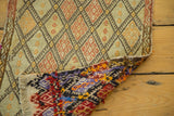 Vintage jijim rug corner, displaying its geometric pattern and colorful hand-woven reverse.