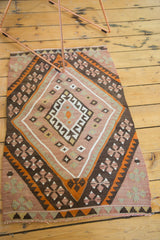 Vintage Kilim rug corner, featuring plum blush, brown, orange geometric motifs and fringe.
