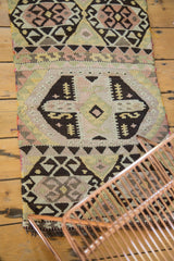 Hand-woven Turkish Kilim corner with dark charcoal crab motif and blush mauve patterns.