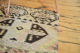 Hand woven Turkish kilim with blush mauve, charcoal black, and pale saffron crab style motif.