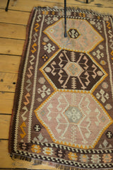 Close-up of Vintage Kilim runner's geometric medallion in blush, dark chocolate, and bronze.