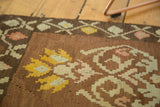 Hand woven village-type Kilim rug with irregular blossoming yellow and blush floral motifs.