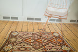 Vintage Turkish Kilim runner displaying paneled geometric patterns in plum, brick red, and beige.
