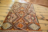 Intricate geometric paneled design in blush, beige, and dark brown on a vintage Kilim rug.