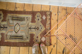 Vintage Kilim rug showcasing hand-woven texture, arrow motifs, and unique wave border.